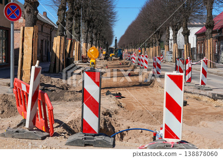 Urban street roadworks with barriers, trenches and machinery during reconstruction project phase Urban street roadworks with barriers, trenches and machinery during reconstruction project phase 138878060