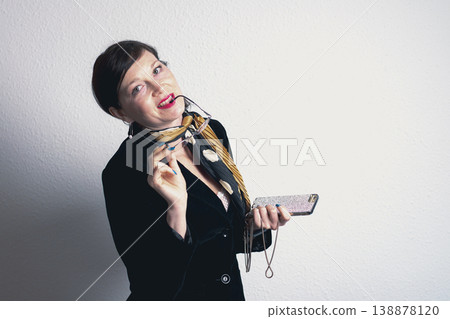 A woman wearing glasses and a yellow scarf is holding a cell phone A woman wearing glasses and a yellow scarf is holding a cell phone 138878120