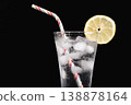 A glass of water with a straw and a lemon slice on top 138878164