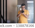 Male photographer with a professional camera taking a self-portrait in front of the mirror at home. 138878166