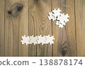 Puzzle pieces scattered across a wooden board. 138878174