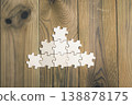 Puzzle pieces arranged in a pyramid shape on a wooden table. 138878175