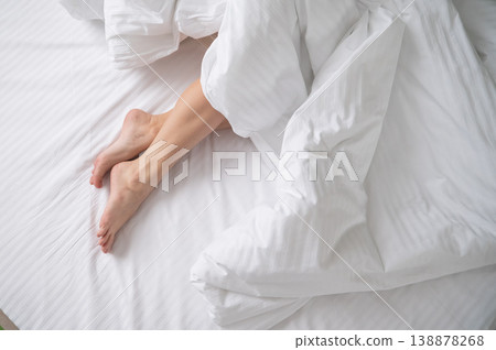 Foot fetish. Bare female feet protruding from under the blanket. 138878268