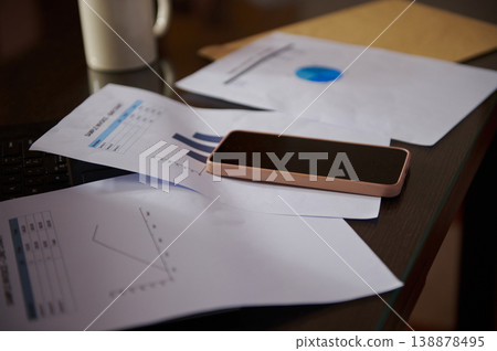 Smartphone On Desk With Business Reports, Charts And Coffee Cup On Home Office Workspace 138878495