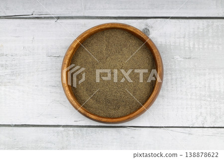 Freshly ground organic black pepper in rustic bowl over wooden surface. Healthy food seasoning Freshly ground organic black pepper in rustic bowl over wooden surface. Healthy food seasoning 138878622