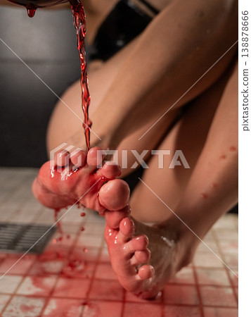 Foot fetish. A woman pours wine from a glass onto her feet in the shower. Foot fetish. A woman pours wine from a glass onto her feet in the shower. 138878666