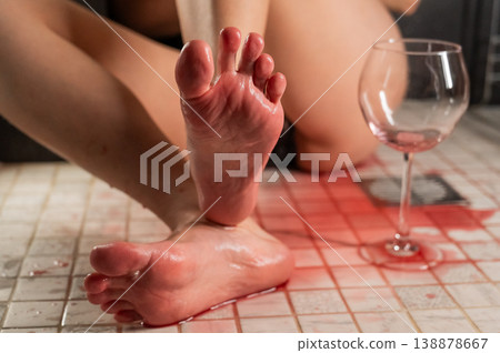 Foot fetish. A woman pours wine from a glass onto her feet in the shower. Foot fetish. A woman pours wine from a glass onto her feet in the shower. 138878667