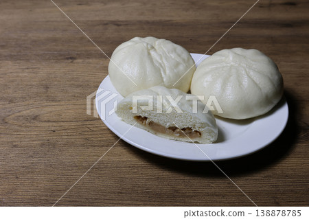 Steamed meat buns on a plate on a wooden background Steamed meat buns on a plate on a wooden background 138878785