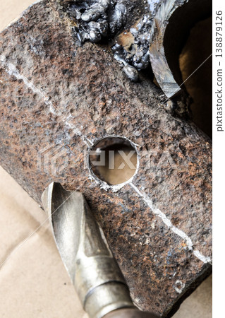 Drill for metal. A drilled hole in the steel part. 138879126