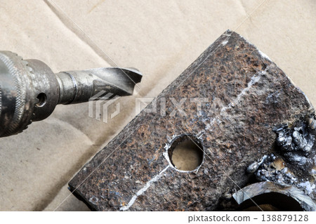 Drill for metal. A drilled hole in the steel part. 138879128