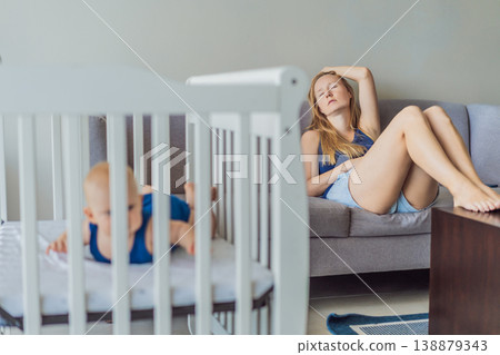 Very tired mother sitting by baby crib at home feeling exhausted. Sleep deprived mom caring for newborn at night. Parenting fatigue, motherhood stress, childcare and real family life concept Very tired mother sitting by baby crib at home feeling exhausted. Sleep deprived mom caring for newborn at night. Parenting fatigue, motherhood stress, childcare and real family life concept 138879343