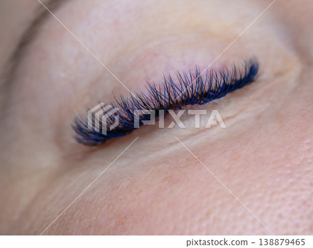 Close-up of a closed female eye with long blue and black volume eyelash extensions Close-up of a closed female eye with long blue and black volume eyelash extensions 138879465