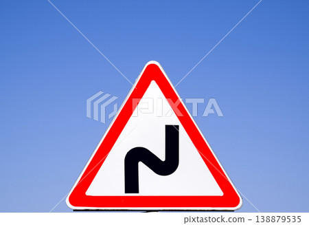 Road sign dangerous turn. Warning sign. 138879535
