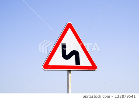 Road sign dangerous turn. Warning sign. Road sign dangerous turn. Warning sign. 138879541