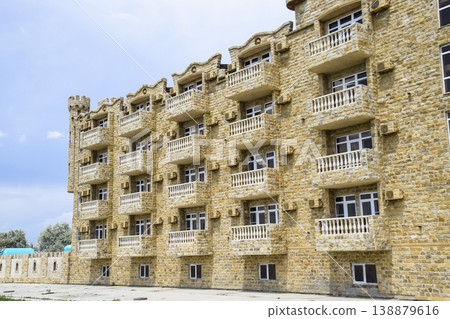 The hotel building, covered with decorative stone. Multi-storey hotel with a decorative trim, which is called Dagestani stone The hotel building, covered with decorative stone. Multi-storey hotel with a decorative trim, which is called Dagestani stone 138879616
