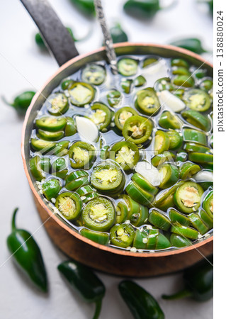 Bowl with jalapeno slices in brine liquid on light background Bowl with jalapeno slices in brine liquid on light background 138880024