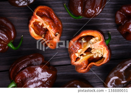 Chocolate habanero peppers with sliced halves showing seeds Chocolate habanero peppers with sliced halves showing seeds 138880031