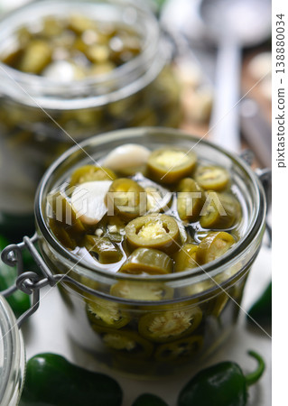 Close up of jar filled with pickled jalapeno slices in brine Close up of jar filled with pickled jalapeno slices in brine 138880034