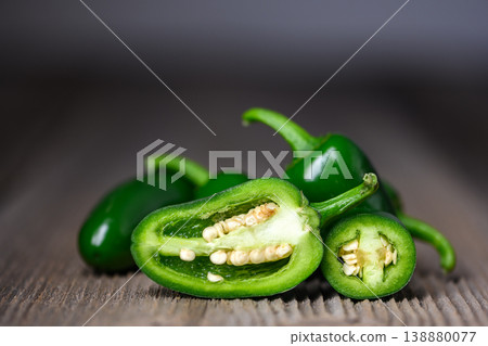 Sliced jalapeno pepper pieces arranged on wooden table Sliced jalapeno pepper pieces arranged on wooden table 138880077