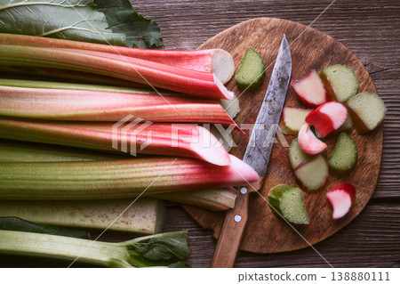 Whole rhubarb stalks with sliced pieces on wooden table Whole rhubarb stalks with sliced pieces on wooden table 138880111