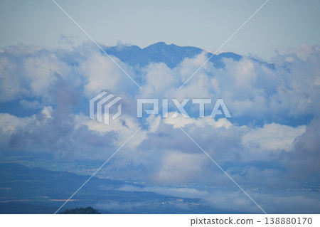透過厚厚的雲層，可以看到遠處北海道的山峰和平原。這是北海道壯麗自然風光的代表，令人嘆為觀止。捕捉了北海道雄偉的自然之美。 138880170