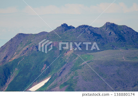 Green slopes and rugged ridgelines of Hokkaido's volcanic rock peaks. A spectacular view representing the magnificent nature of Hokkaido. The wind captures the majestic natural beauty of Hokkaido. 138880174