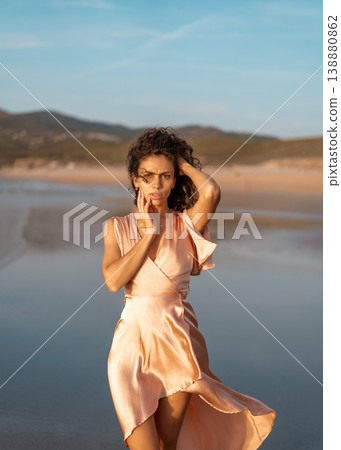 Elegant woman in satin dress posing on beach with Elegant woman in satin dress posing on beach with 138880862