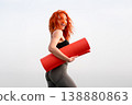 Cheerful sporty woman holding red exercise mat 138880863