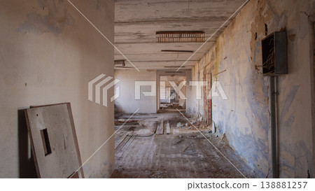 Long Peeling Corridor In Exclusion Zone, Cracked Plaster Walls, Scattered Rubble And Exposed Wiring, Dim Long Peeling Corridor In Exclusion Zone, Cracked Plaster Walls, Scattered Rubble And Exposed Wiring, Dim 138881257