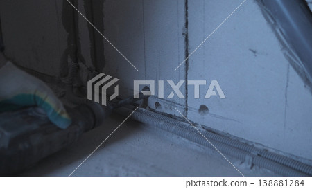 Securing Cable Channel With Gloves. Worker Uses Gloves While Installing Conduit Safely. Closeup Of Technician Wearing Gloves While Securing And Installing Electrical Conduit Safely Securing Cable Channel With Gloves. Worker Uses Gloves While Installing Conduit Safely. Closeup Of Technician Wearing Gloves While Securing And Installing Electrical Conduit Safely 138881284