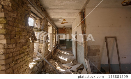 Sunlit Domestic Ruin With Leaning Plaster, Fractured Windows And Scattered Household Debris Intimate Interior Suggests Civilian Home Damaged By Conflict And Slow Process Of Documenting Loss 138881299