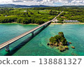 Aerial view of the emerald green sea with Kouri Bridge and small rocky reefs in Okinawa. 138881327