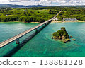Aerial view of the emerald green sea with Kouri Bridge and small rocky reefs in Okinawa. 138881328