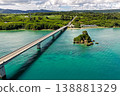 Aerial view of the emerald green sea with Kouri Bridge and small rocky reefs in Okinawa. 138881329