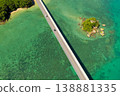 An aerial view of Kouri Bridge and a small island in Okinawa, seen from directly above, against the backdrop of the emerald green sea. 138881335