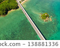 An aerial view of Kouri Bridge and a small island in Okinawa, seen from directly above, against the backdrop of the emerald green sea. 138881336