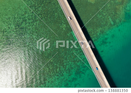 An aerial view of Kouri Bridge in Okinawa, seen from directly above, against the backdrop of the emerald green sea. An aerial view of Kouri Bridge in Okinawa, seen from directly above, against the backdrop of the emerald green sea. 138881350