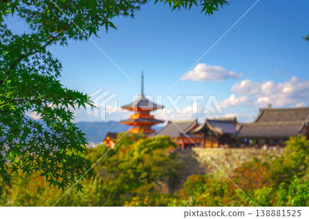 Kyoto, Japan - Oct 11 2024, panoramic view through foliage of Kiyomizu-Dera temple complex with a pagoda, with a clear blue sky and a forest in foreground, at daytime, blurred, Kyoto, Japan Kyoto, Japan - Oct 11 2024, panoramic view through foliage of Kiyomizu-Dera temple complex with a pagoda, with a clear blue sky and a forest in foreground, at daytime, blurred, Kyoto, Japan 138881525