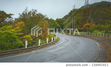 Muroran, Hokkaido, Japan - Oct 4 2024, panoramic view of a country paved road passing through forests and fields, without cars and without people, in cloudy weather, at daytime, Muroran, Japan 138881911