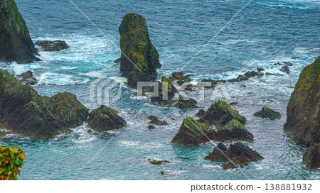 Muroran, Hokkaido, Japan - Oct 04 2024, panoramic aerial view of the picturesque Pacific ocean coast with sharp cliffs and high mountain slopes, in a storm, it's raining, at daytime, Muroran, Japan Muroran, Hokkaido, Japan - Oct 04 2024, panoramic aerial view of the picturesque Pacific ocean coast with sharp cliffs and high mountain slopes, in a storm, it's raining, at daytime, Muroran, Japan 138881932