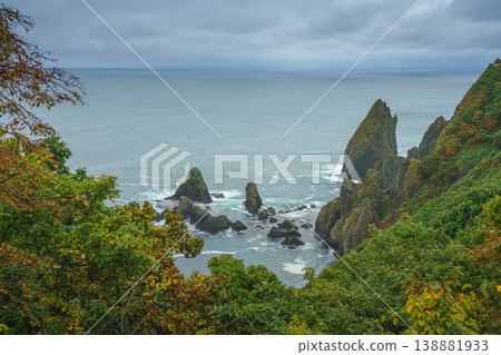 Muroran, Hokkaido, Japan - Oct 04 2024, panoramic aerial view of the picturesque Pacific ocean coast with sharp cliffs and high mountain slopes, in a storm, it's raining, at daytime, Muroran, Japan Muroran, Hokkaido, Japan - Oct 04 2024, panoramic aerial view of the picturesque Pacific ocean coast with sharp cliffs and high mountain slopes, in a storm, it's raining, at daytime, Muroran, Japan 138881933