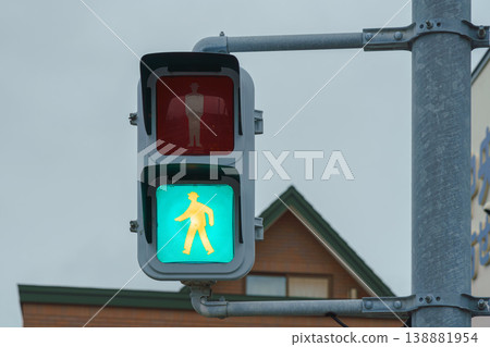 Muroran, Hokkaido, Japan - Oct 04 2024, close up view of a pedestrian traffic light with a green permit light on, at daytime, Muroran, Japan Muroran, Hokkaido, Japan - Oct 04 2024, close up view of a pedestrian traffic light with a green permit light on, at daytime, Muroran, Japan 138881954