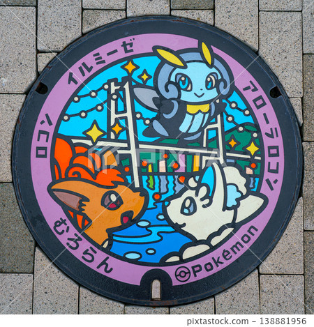 Muroran, Hokkaido, Japan - Oct 4 2024, A close-up view of a manhole with a color image of three cute Pokemon on background of Hakucho Bridge, Muroran, Japan Muroran, Hokkaido, Japan - Oct 4 2024, A close-up view of a manhole with a color image of three cute Pokemon on background of Hakucho Bridge, Muroran, Japan 138881956