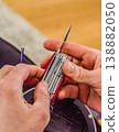 Close up of a handyman using a versatile red multitool to strip electrical wires. DIY home improvement and repair project. High quality photo 138882050