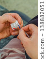 Close-up of male hands carefully connecting brown and blue electrical wires into a white plastic terminal block during home renovation work.. High quality photo 138882051