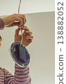 An electrician connects the electrical wires for a modern, energy-efficient recessed ceiling light. Home improvement and repair.. High quality photo 138882052