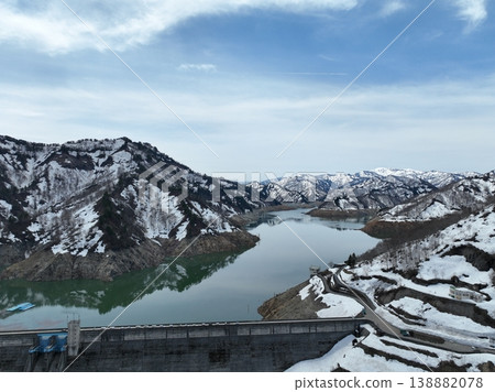 <Bird's-eye view> Lake Okutadami awaiting spring, with snow-capped mountains beautifully reflected on the lake's surface. 138882078