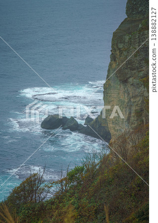 Muroran, Hokkaido, Japan - Oct 04 2024, vertical aerial view of the picturesque Pacific ocean coast with sharp cliffs and high mountain slopes, in a storm, it's raining, at daytime, Muroran, Japan 138882127