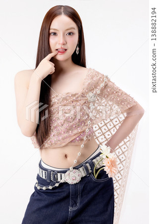 Modern trendy Thai fashion woman wearing a traditional Sabai paired with denim jeans, reflecting the growing fashion trend in Thailand that blends cultural heritage with contemporary street style. 138882194