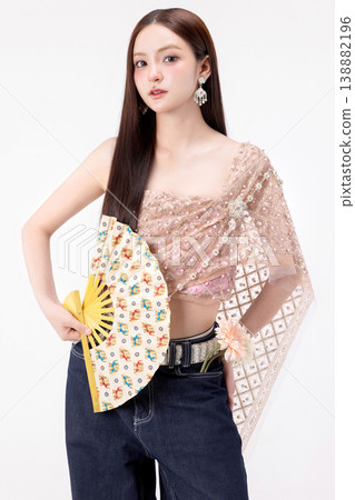 Modern trendy Thai fashion woman wearing a traditional Sabai paired with denim jeans, reflecting the growing fashion trend in Thailand that blends cultural heritage with contemporary street style. 138882196